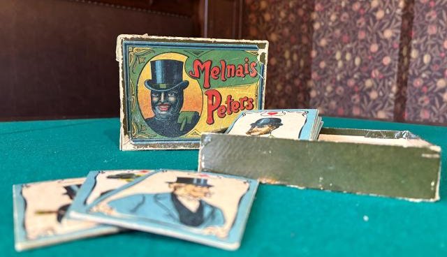 Kāršu spēļu komplekts Melnais Peters, uz zaļa spēļu galda pils salonā